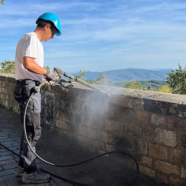 Volunteers pressure washing a wall