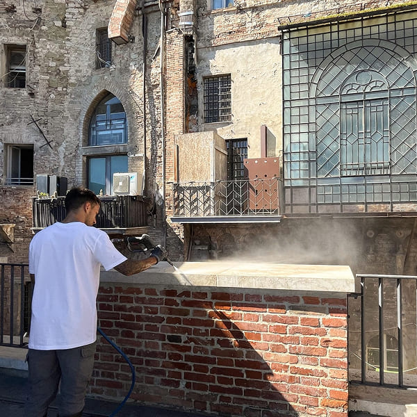 Man cleaning a railing with a pressure washer