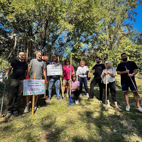 Volunteers standing with shovels and rakes